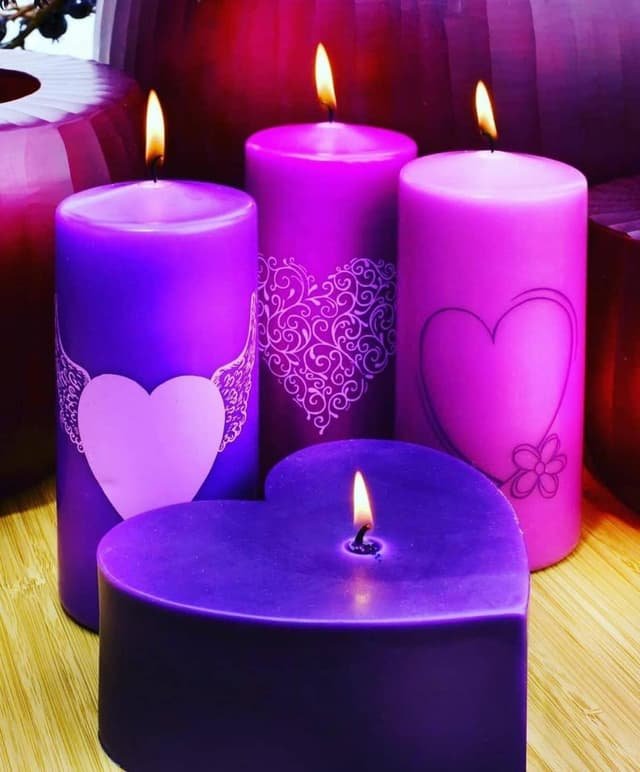 Velas moradas con corazones encendidas para un endulzamiento de amor